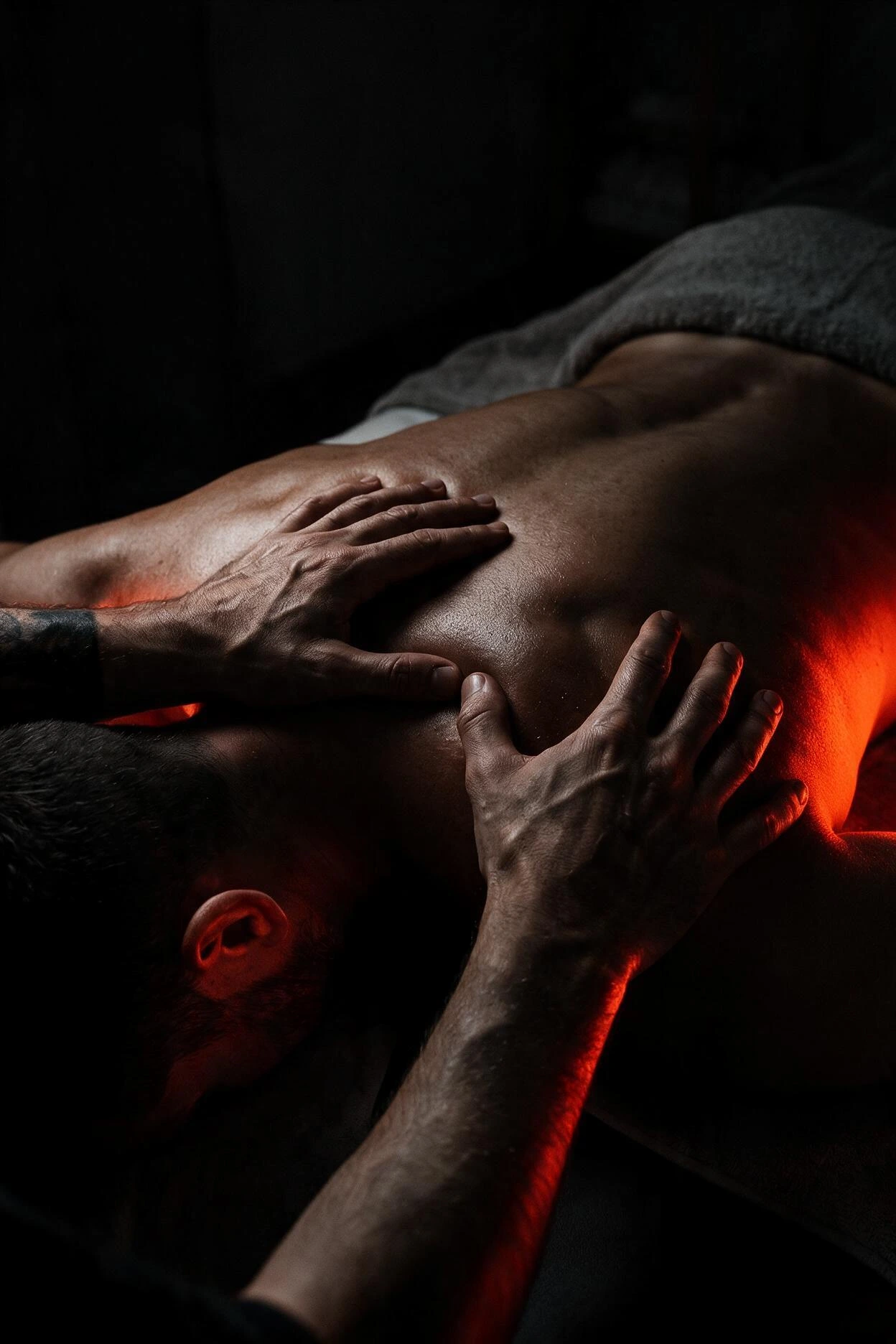 Bodywork practitioner working across a client’s back